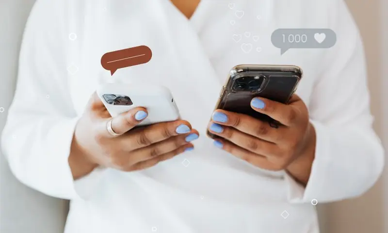 Dos manos con móviles y avisos de me gusta