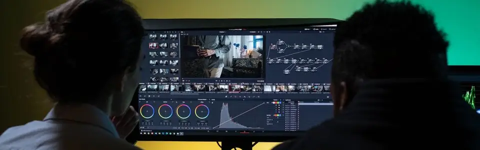 Dos personas editando un vídeo en un monitor